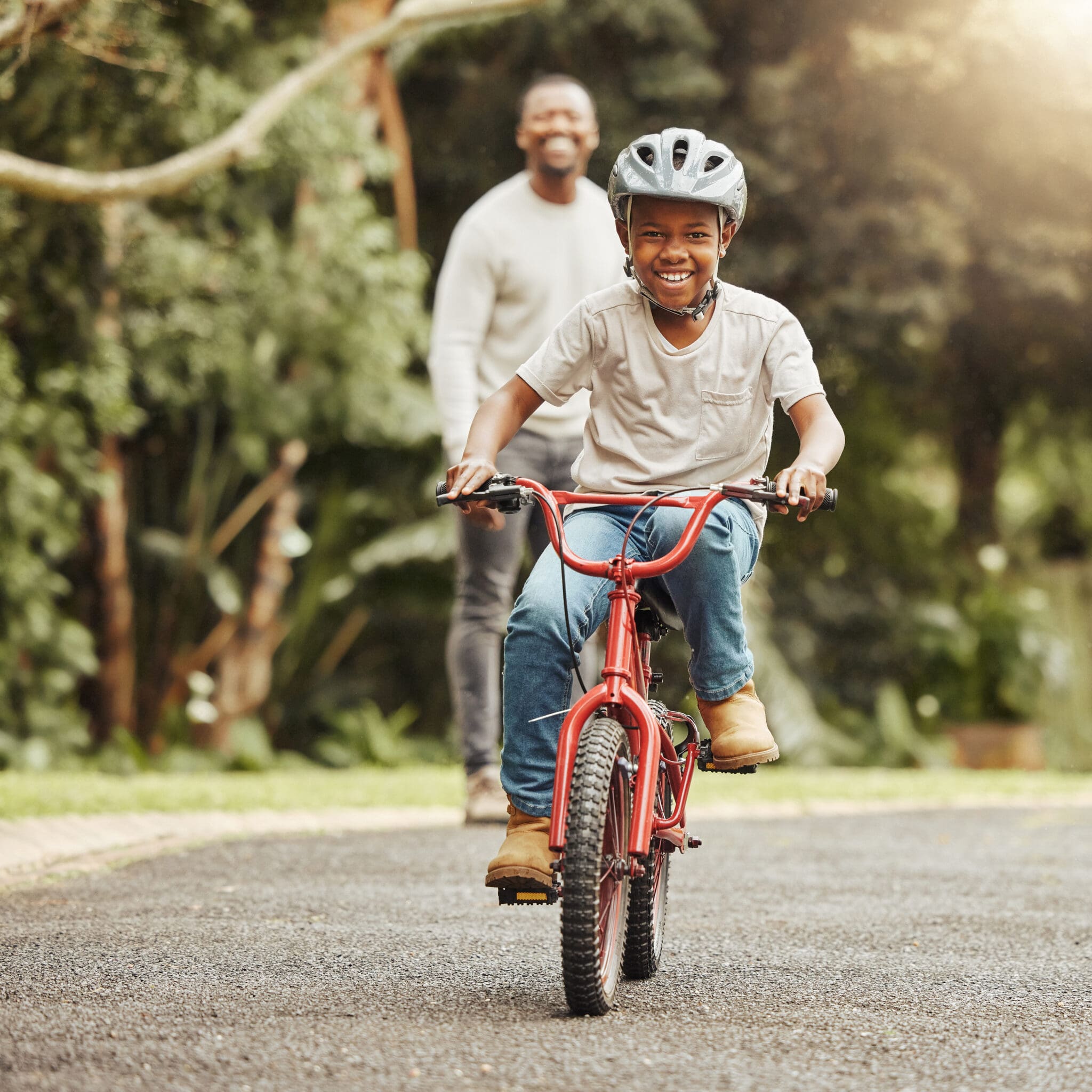 A man and woman riding on the back of a red bicycle.