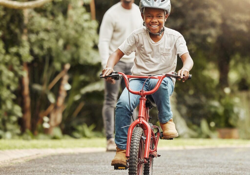 A man and woman riding on the back of a red bicycle.